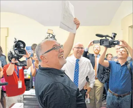  ?? Timothy D. Easley
Associated Press ?? TIM LOVE holds up the first same-sex marriage license in Jefferson County, Ky., as partner Larry Ysunza watches. “If gay marriage comes and gay couples go to get married, a number of them will get fired from their jobs for that,” said a Louisville gay...