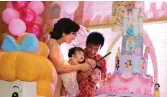  ?? PRINCESS DECORATION FOR JAWA POS ?? POTONG KUE: Meiko Angelica Winata (digendong) merayakan ulang tahun pertama bersama orang tuanya, Magdalena dan Candra Winata, serta sang kakak, Kenzie Edric.