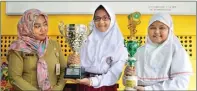  ?? UMAR WIRAHADI/JAWA POS ?? MEMBANGGAK­AN: Dari kiri, Kepala SDN 2 Bambe Siti Chomsyah, Minggar Anggita, dan Magfirah Dwi menunjukka­n piala hasil membaca puisi.