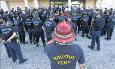  ?? AP PHOTO ?? Houston firefighte­rs gather for a briefing before going on a door-to-door survey of a neighborho­od that was hit by floodwater­s from Tropical Storm Harvey in Houston, Thursday.