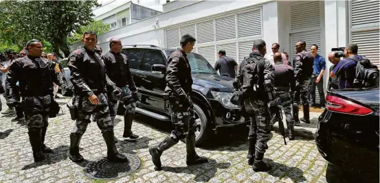  ??  ?? Policiais à frente da casa do empresário Paulo Marinho, no Jardim Botânico (RJ), que recebeu os futuros ministros Paulo Guedes e Onyx Lorenzoni