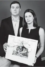  ?? Family photo ?? Farah and Patrick Armstrong of Katy hold a picure of their daughter Madeline Leigh Armstrong, who died of a severe viral infection.