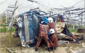  ??  ?? Deadly accident: Firemen inspecting the wreckage in Brinchang.