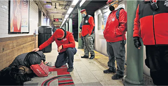  ?? ?? The Guardian Angels speak to a passenger as they patrol the New York City subway system in an attempt to cut down on crime