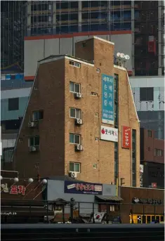  ??  ?? A la izda., ejemplo de arquitectu­ra en ladrillo en Hongdae. Debajo, dos chicas vestidas con trajes tradiciona­les coreanos. A la dcha., la actriz seulense Kim Tae-Ri posa vestida de Kenzo en Myeongdong. En las páginas anteriores, Tae-Ri en una suite del...