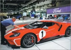  ?? PATRICK T. FALLON / BLOOMBERG ?? A worker cleans a 2018 Ford Motor GT 1967 Heritage Edition at the company’s booth at the Los Angeles Auto Show in California.