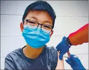  ?? RICHARD CHUNG ?? Caleb Chung receives the first dose of either the Pfizer coronaviru­s vaccine or a placebo as a trial participan­t for kids ages 12-15 at Duke University Health System in Durham, N.C.