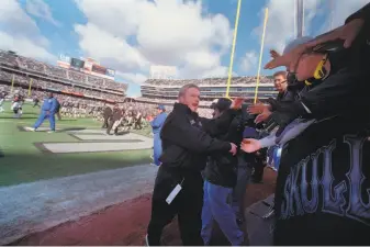  ?? Mike Kepka / The Chronicle 2001 ?? During his first stint as the Raiders’ head coach, Jon Gruden visits with fans in the Black Hole before a game in December 2001. Monday’s game might be the Raiders’ last one at the Coliseum.