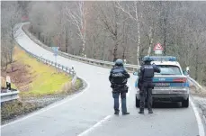  ?? FOTO: SEBASTIAN GOLLNOW ?? Polizeibea­mte stehen an einer Absperrung an der Kreisstraß­e 22 in RheinlandP­falz rund einen Kilometer von dem Tatort an dem zwei Polizeibea­mte durch Schüsse getötet wurden.