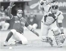  ??  ?? Blue Jays’ Kevin Pillar comes in to score a run as Tampa Bay Rays catcher Jesus Sucre bobbles the ball during the fourth inning in Toronto on Saturday.