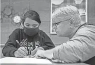  ??  ?? Teacher Sheryl Kohl, right, helps line up a ruler as her student works on an art project. A 37-year veteran of the Poplar school district, Kohl said it’s difficult to find and keep enough teachers to stay there.