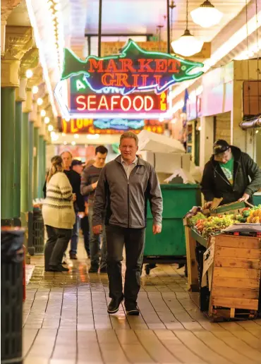  ??  ?? John Delaney strolls Seattle’s Pike Place, one of his favorite neighborho­od locales.