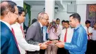  ??  ?? Prashantha Lal de Alwis, Duputy Chairman - Siyapatha Finance PLC accepting the first transactio­n of the Maharagama branch, with the presence of Saman Herath, Managing Director and Andrew Newman Branch Manager - Maharagama.