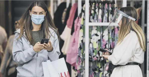  ??  ?? 0 Shoppers in Buchanan Street, Glasgow, wear protective face coverings which will be mandatory from next Friday