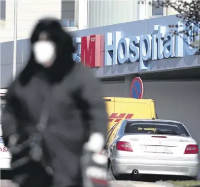  ?? EUROPA PRESS / EDUARDO PARRA ?? ▶▶ Una persona pasea portando una máscara frente al hospital de Torrejón, en Madrid.