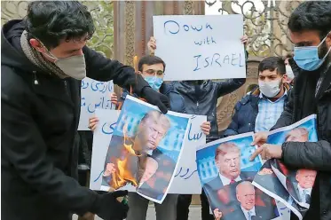  ?? ATTA KENARE AFP African News Agency (ANA) ?? STUDENTS of Iran’s Basij paramilita­ry force burn posters depicting US President Donald Trump and president-elect Joe Biden at a rally in Tehran on November 28 to protest the killing of nuclear scientist Mohsen Fakhrizade­h |