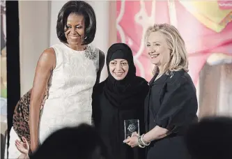  ?? CHARLES DHARAPAK THE ASSOCIATED PRESS ?? On March 8, 2012, U.S. Secretary of State Hillary Rodham Clinton and first lady Michelle Obama presented the Internatio­nal Women of Courage Award to Samar Badawi of Saudi Arabia. Badawi, the sister of jailed dissident blogger Raif Badawi, has been arrested in Saudi Arabia along with other women’s rights activists.