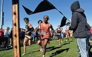  ?? ?? The AA Boys race runs around the corner of the course during the Cross Country State Championsh­ip on Oct. 21 at Yankton Trail Park in Sioux Falls.