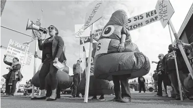  ?? Ted S. Warren / Associated Press ?? Erna Hankic, left, vice president of Local #6 of the Service Employees Internatio­nal Union, leads chants outside Amazon’s shareholde­rs meeting Wednesday in Seattle. SEIU called attention to what it called poor conditions for workers with security contractor Security Industry Specialist­s.