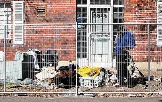  ?? (AP Photo/thomas Peipert) ?? A homeless man sifts through his belongings during a sweep of an encampment Oct. 31 in downtown Denver. Crews erected fencing along several blocks near a post office, and police ordered campers to leave. More cities across the U.S. are cracking down on homeless tent encampment­s that have grown more visible and become unsafe.