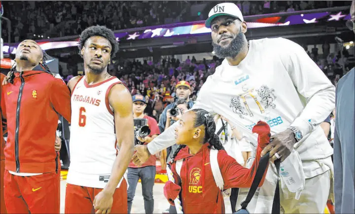  ?? Jason Armond Los Angeles Times/tns ?? Lakers star Lebron James, right, pats the back of his son, Bronny James, before a Southern California game earlier this season.