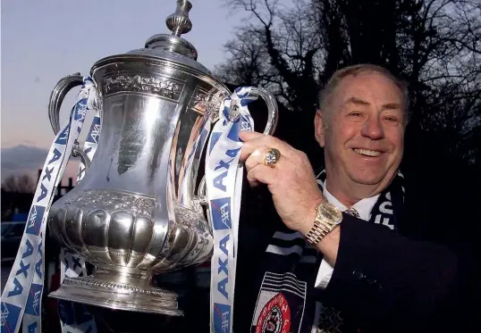  ?? GETTY IMAGES ?? George Reynolds poses with the FA Cup in 1999, when Darlington became the first team to lose a cup tie and still qualify for the next round. Manchester United had to withdraw because of other commitment­s, and Darlington won a draw of ‘‘lucky losers’’.