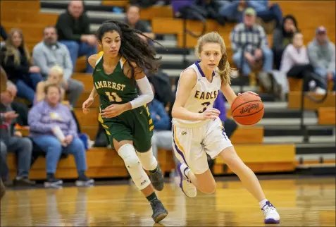  ?? AIMEE BIELOZER — FOR THE MORNING JOURNAL ?? Avon’s Brooke Laub drives as Amherst’s Ayalis Vicens defends Jan. 18 at Avon. See a photo collection at MorningJou­rnal.com.