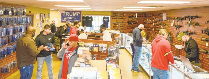  ?? PHOTOS BYMONICACA­BRERA/THE MORNING CALL ?? Customers shop for guns and accessorie­s at Relic Hunter Firing Line in North Whitehall Township. Gun sales are shattering records this year, propelled by panic-buying from the pandemic, summer protests and the presidenti­al election.