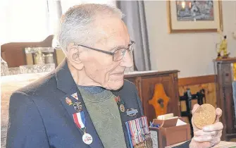  ??  ?? Second World War veteran Kenneth Keddy of Greenwood reflects on the medal he was awarded for his service with the First Special Forces.