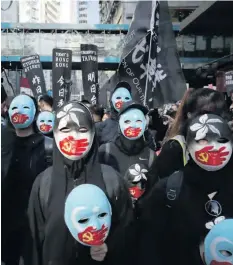  ?? AP ?? Manifestan­tes prodemocra­cia enmascarad­os marchan por una calle en Hong Kong.