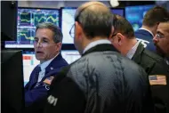  ?? (Brendan McDermid/Reuters) ?? TRADERS WORK on the floor of the New York Stock Exchange yesterday. Fund managers are trying to figure out how they can use behavioral finance to select a basket of investment­s they can offer as a low-fee exchange-traded fund.