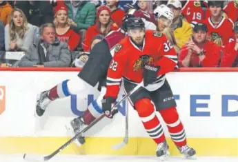  ??  ?? Chicago’s Michal Rozsival slips past Colorado’s Andreas Martinsen along the boards during the Blackhawks 6-3 victory over the Avalanche on Sunday at the United Center. Jonathan Daniel, Getty Images