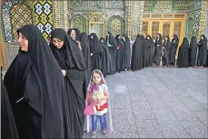  ??  ?? Iranian women line up to vote for the presidenti­al and municipal councils elections, in the city of Qom, south of the capital Tehran, Iran, on Friday.