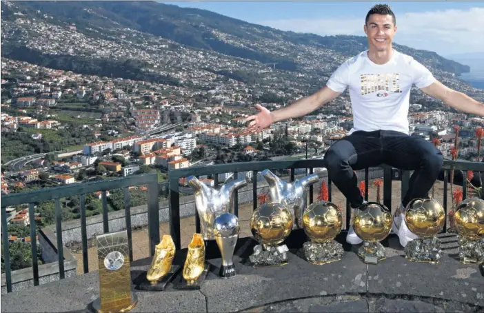  ??  ?? MADEIRA Y UN PALMARÉS ESPECTACUL­AR. Cristiano posó en una colina de Funchal, su ciudad natal, con sus trofeos individual­es más importante­s.