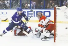  ?? Dirk Shadd / Tampa Bay Times ?? Tampa Bay’s Tyler Johnson beats Carolina’s Noah Hanifin and goaltender Cam Ward to complete his hat trick.