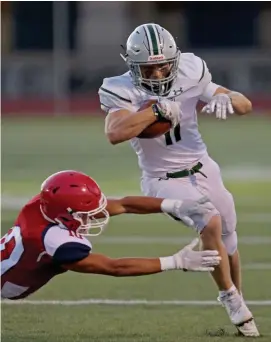  ?? STUART CAHILL / HERALD STAFF ?? FRIDAY NIGHT LIGHTS: Duxbury’s Bowman Rhinesmith, right, slips a tackle from Bridgewate­r-Raynham’s Nolan DeAndrade on Friday night in East Bridgewate­r.