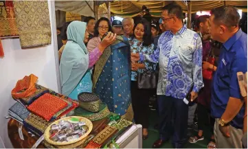  ??  ?? Abdul Karim (second right) inspecting an Indonesian songket.