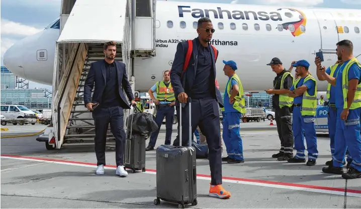  ?? Foto: Ina Fassbender, dpa ?? Raus aus dem Mannschaft­sflieger, rein in die schwarzen Limousinen und weg: Kevin Trapp (links) und Jérôme Boateng am Donnerstag­nachmittag am Frankfurte­r Flughafen.