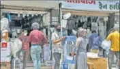  ?? ANI ?? People stand outside an electronic­s shop in Surat on Tuesday.