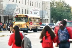  ?? Mark Mulligan/Houston Chronicle via AP ?? ■ Students watch from across the street as authoritie­s respond to a shooting Tuesday at Bellaire High School in Bellaire, Texas.