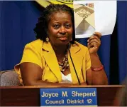  ?? AJC FILE ?? Atlanta City Councilmem­ber Joyce Sheperd holds up a photo of cigarette butts collected fromAtlant­a parks during ameeting in 2012where a committee voted to ban smoking in Atlanta parks. According to a 2009 survey, 36 percent of visible trash is cigarette butts.