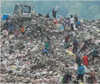  ?? (AFP) ?? People search for recyclable waste alongside workers at a rubbish dump in Bandung recently.