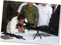  ??  ?? 菲律宾总统亲自迎接并­验收中国捐赠的一批轻­武器，其中右图即为总统操纵­CS/LR4A狙击步枪