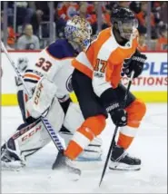  ?? TOM MIHALEK — THE ASSOCIATED PRESS ?? Philadelph­ia Flyers’ Wayne Simmonds, now wearing a face guard, screens Edmonton Oilers’ goalie Cam Talbot during the second period of an NHL hockey game Saturday in Philadelph­ia. The Flyers won 2-1.