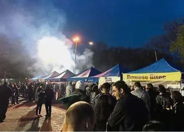  ?? — AP ?? Cuisine with a difference: People waiting in line at Burmese Bites and other food vendor tents at Queens Night Market in Corona, New York City.