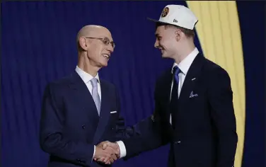  ?? Sarah Stier / Getty Images North America ?? NBA commission­er Adam Silver (L) and Christian Braun react after Braun was drafted with the 21st overall pick by the Denver Nuggets during the 2022 NBA Draft at Barclays Center on June 23.