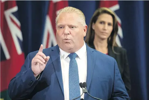  ?? CHRIS YOUNG / THE CANADIAN PRESS ?? Ontario Premier Doug Ford answers questions from journalist­s Thursday as Ontario Attorney-general Caroline Mulroney looks on during a press announceme­nt on a $25-million commitment over four years to fight guns and gangs in Toronto.