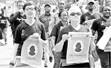  ?? — AFP photo ?? Rovoal (left) and Malac (right) walk with protesters during the women’s march demanding police action to stop a spate of kidnapings and murders of women in Kampala, Uganda.