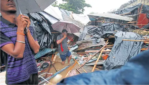  ??  ?? DEVASTATIO­N: The remains of shanty towns destroyed when flooding caused walls to collapse on to the dwellings in Mumbai