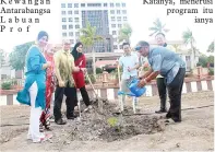  ??  ?? KETUA Sektor Perpustaka­an, Baharin Entoh (kanan) menyiram pokok durian sambil diperhatik­an kakitangan­nya.